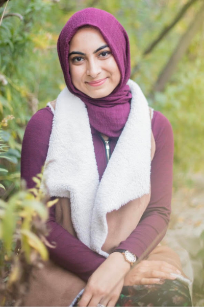 muslim girl wearing red hijab headscarf sitting in forest